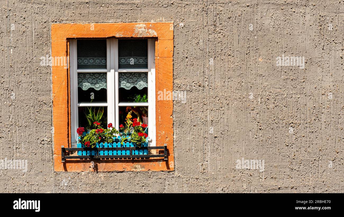 Una finestra colorata su un edificio grigio Foto Stock