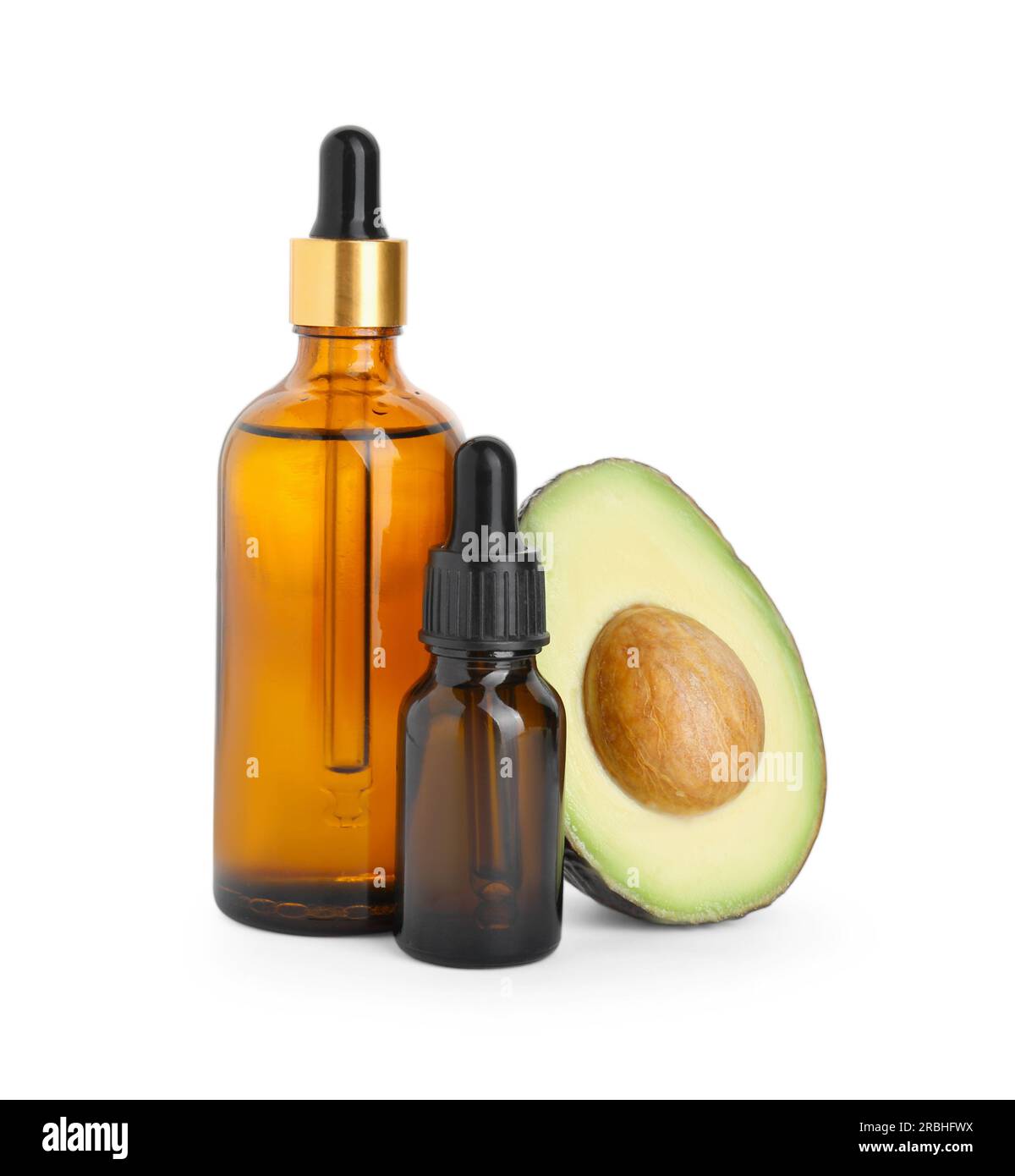 Bottiglie di olio essenziale e avocado tagliato su fondo bianco Foto Stock
