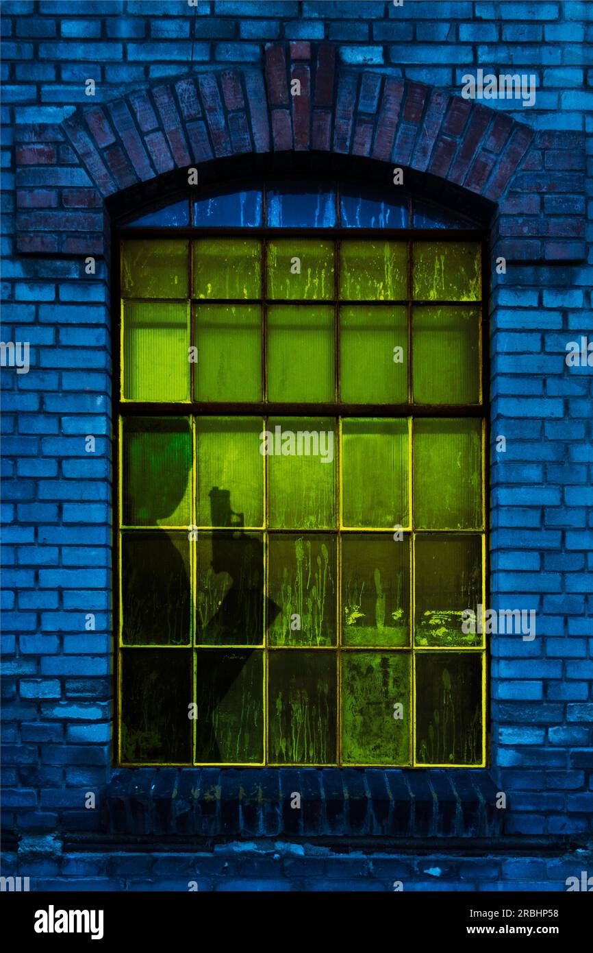 silhouette di un uomo con una mano dietro una finestra Foto Stock