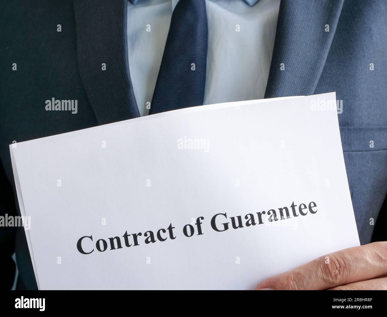 L'uomo vestito ha un contratto di garanzia. Foto Stock