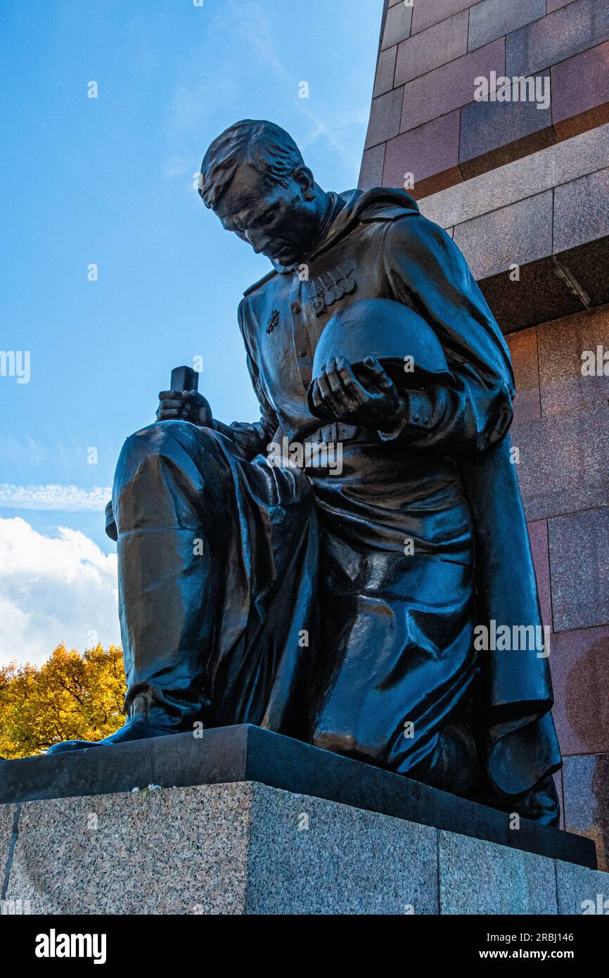 Scultura in bronzo di un soldato in ginocchio con pistola e casco al Memoriale di guerra sovietico a Treptow Park, Berlino, Germania Foto Stock