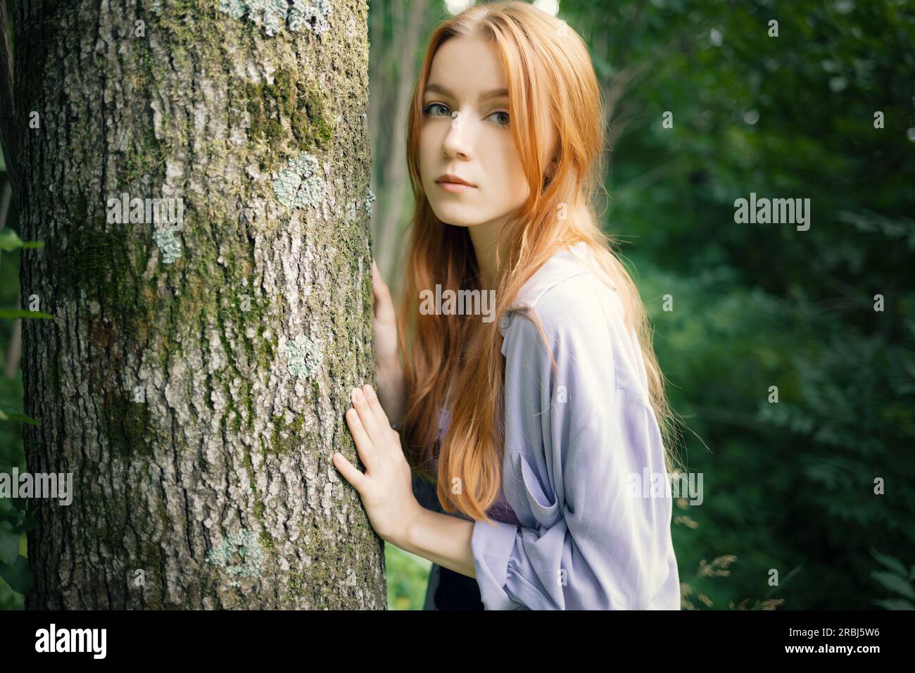 Bella ragazza con i capelli rossi in una passeggiata nel parco. Foto Stock