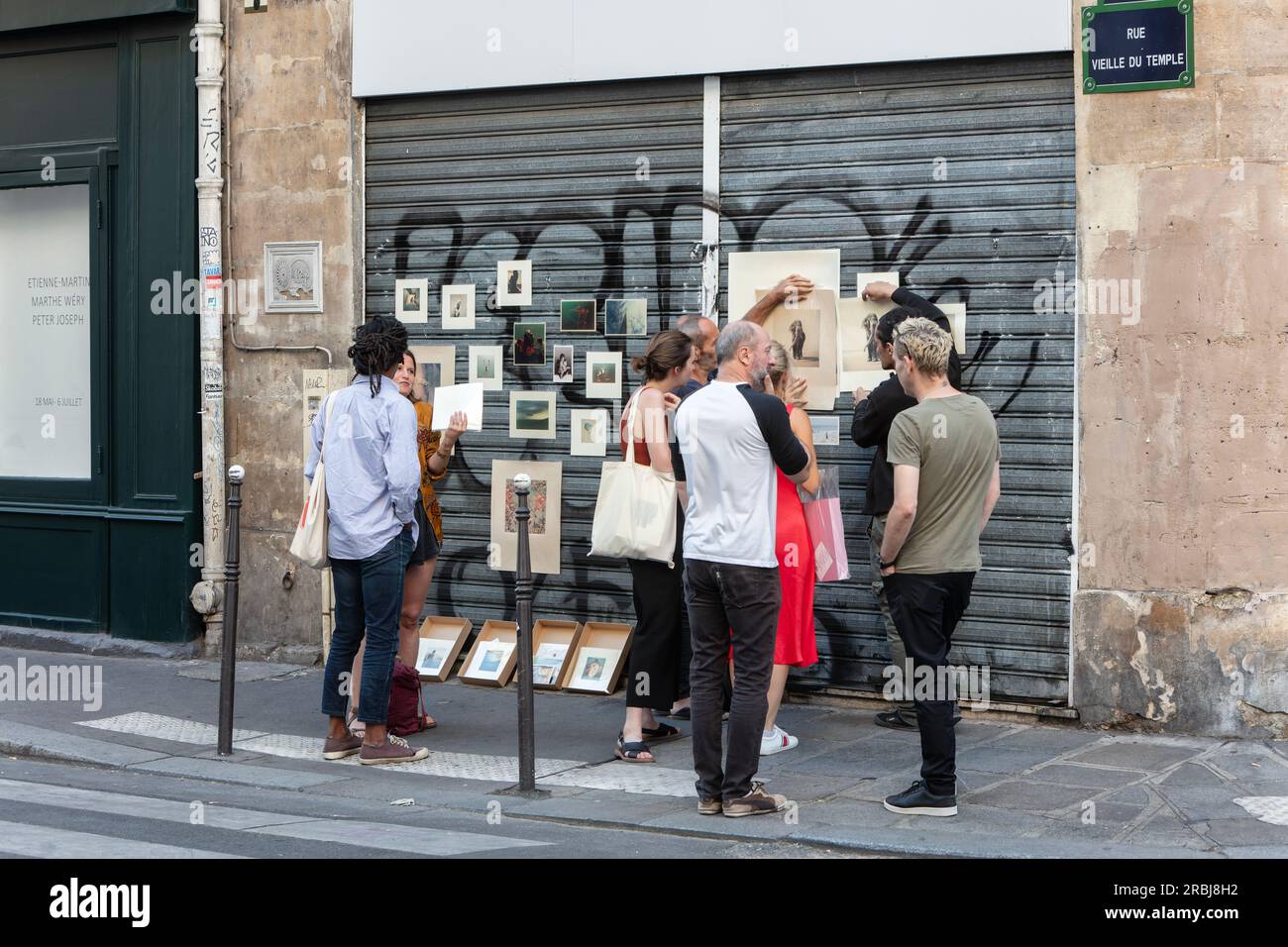 Le persone visitano e discutono di una galleria d'arte improvvisata e temporanea in Rue Vielle du Temple, 3 Arr. Parigi Foto Stock