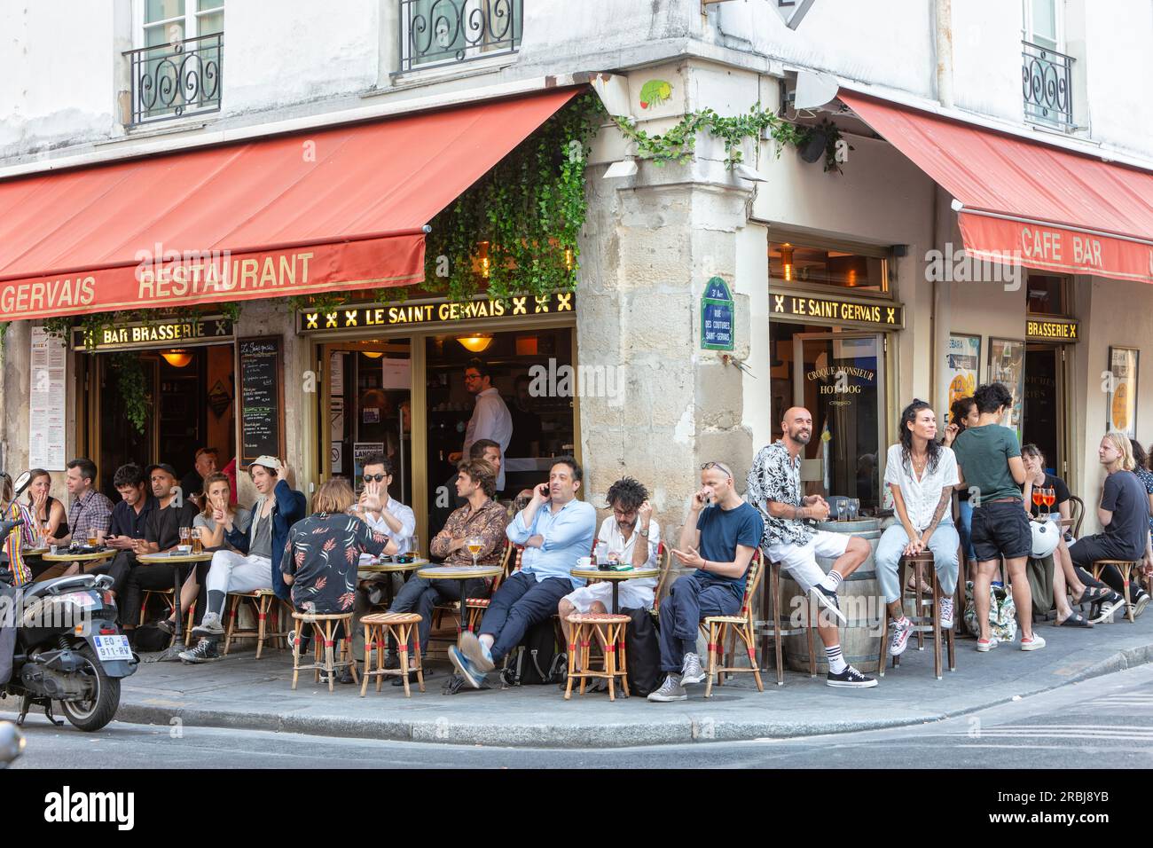 Persone che si divertono a mangiare e bere all'aperto al caffè, bar, ristorante, bistrot le Saint Gervais in Rue Vieille-du-Temple, 3 Arr. Parigi. Foto Stock