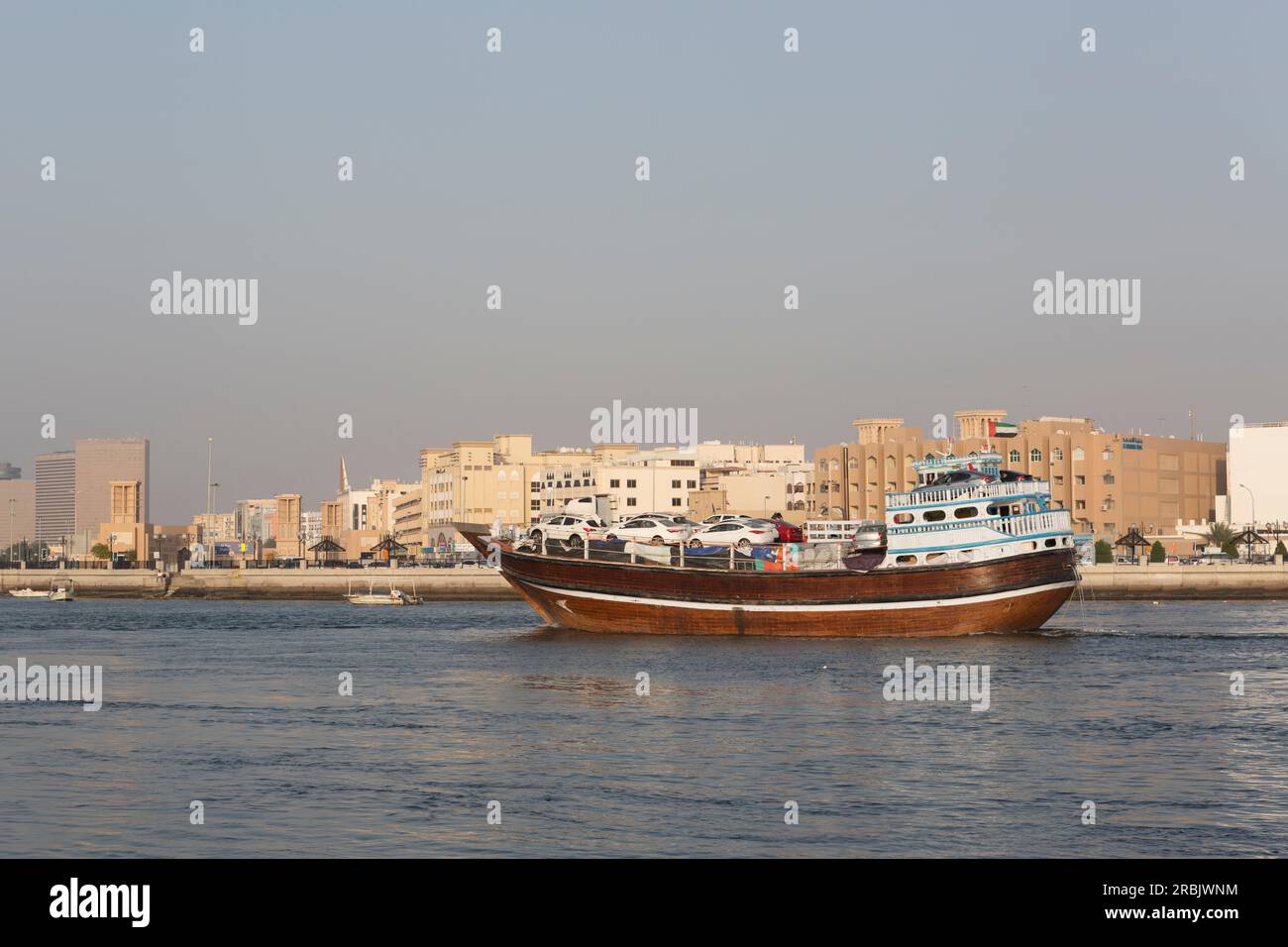 Emirati Arabi Uniti, Dubai, fai trading di dhow con auto nuove a bordo nel Dubai Creek. Foto Stock