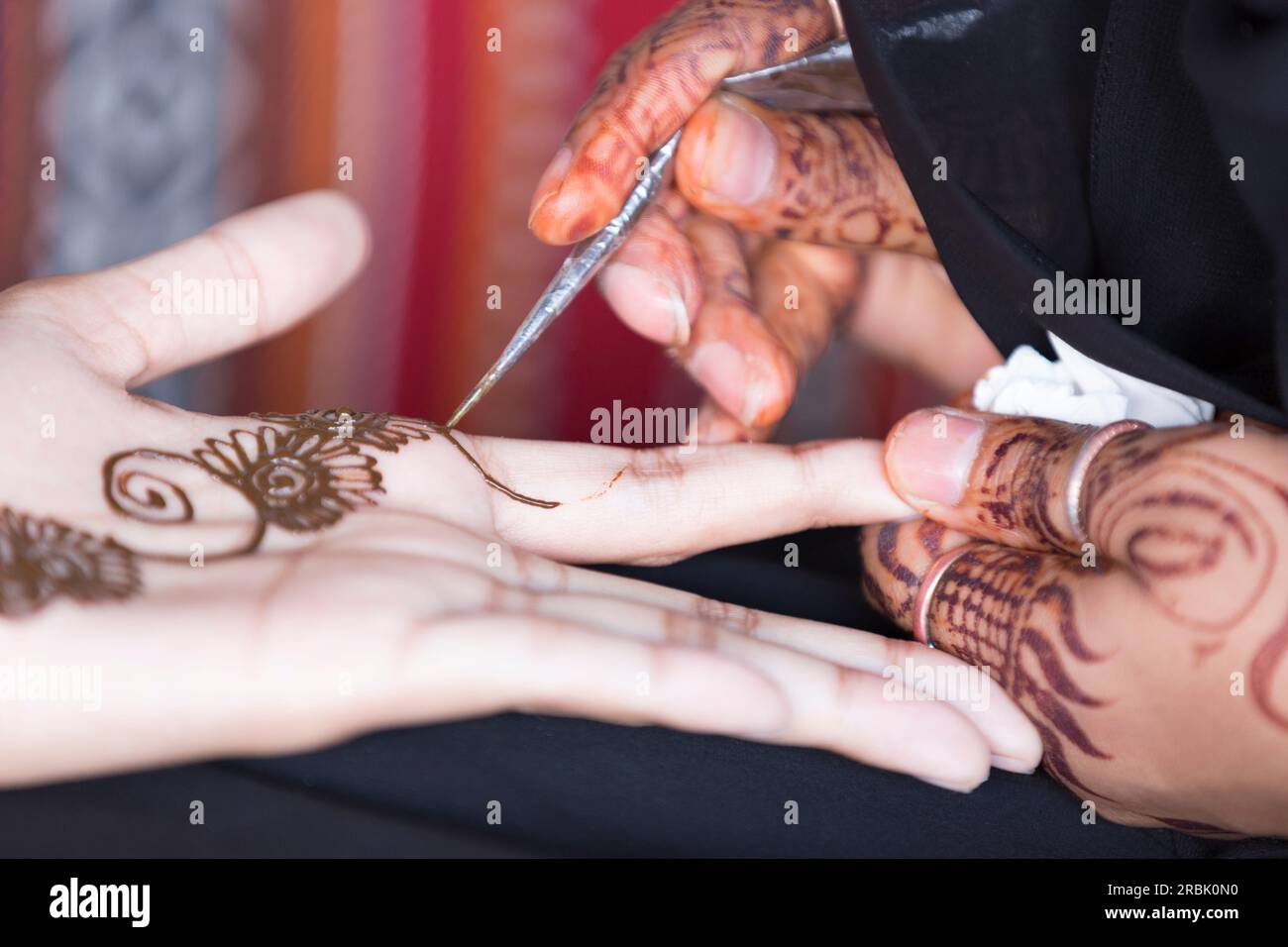 Emirati Arabi Uniti, Dubai, artigiana che applica l'Henna alla mano di qualcuno. Foto Stock
