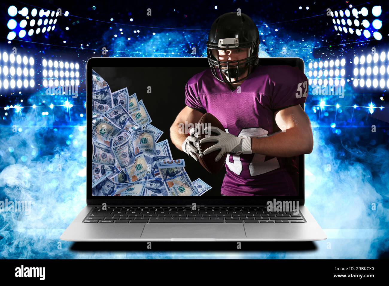 Scommesse sportive. Giocatore di football americano con la palla che appare dal computer portatile sotto le luci dello stadio. Denaro sullo schermo del dispositivo Foto Stock