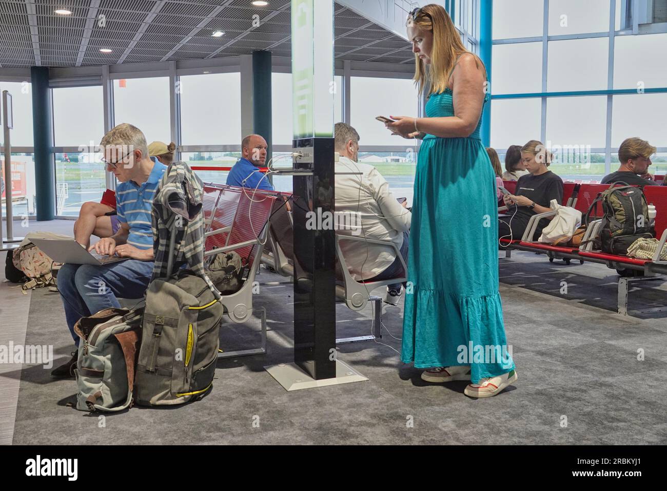 3 luglio 2023 - Aeroporto di Biarritz, Francia. I passeggeri dell'aeroporto di Biarritz che utilizzano i loro dispositivi digitali e l'aeroporto ha fornito delle porte di ricarica durante il periodo Foto Stock