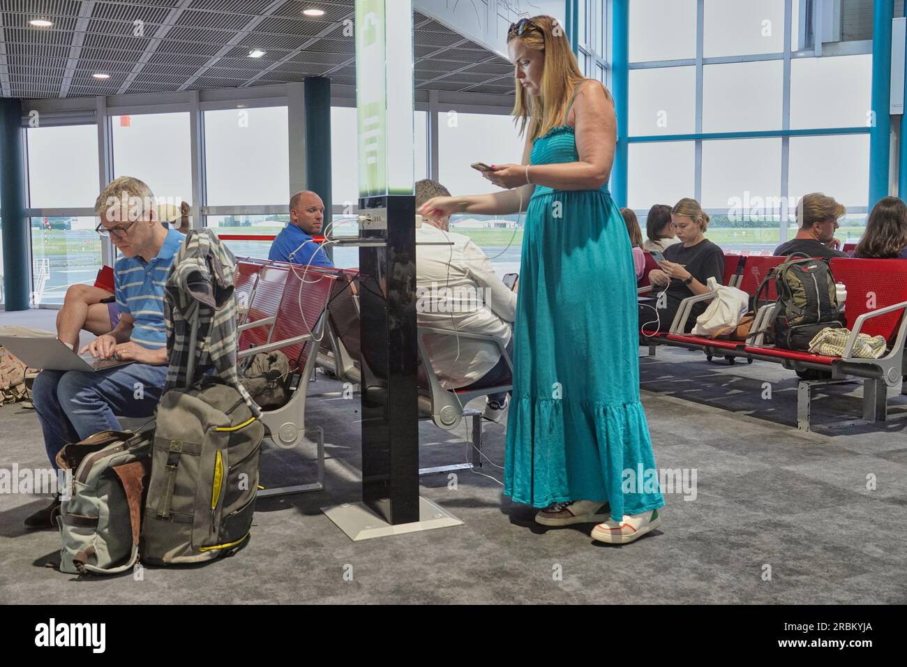 3 luglio 2023 - Aeroporto di Biarritz, Francia. I passeggeri dell'aeroporto di Biarritz che utilizzano i loro dispositivi digitali e l'aeroporto ha fornito delle porte di ricarica durante il periodo Foto Stock