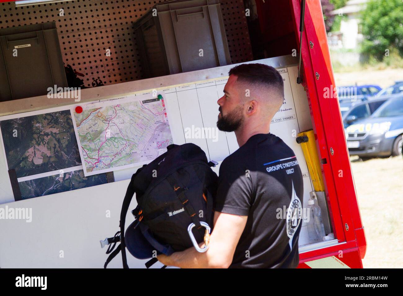 Vernet, Francia. 10 luglio 2023. Un vigile del fuoco prende la sua borsa, dietro di lui una mappa IGN del settore. La polizia francese è impegnata in una vasta ricerca aerea e terrestre di un ragazzo scomparso di due anni, scomparso da un villaggio nel sud del paese nel fine settimana. Il bambino, Émile, stava giocando nel giardino della casa dei nonni in un borgo appena fuori le Vernet nelle Alpi dell'alta Provenza tra Grenoble e Nizza quando è scomparso il sabato pomeriggio. Vernet, Francia, 10 luglio 2023. Foto di Thibaut Durand/ABACAPRESS.COM Credit: Abaca Press/Alamy Live News Foto Stock