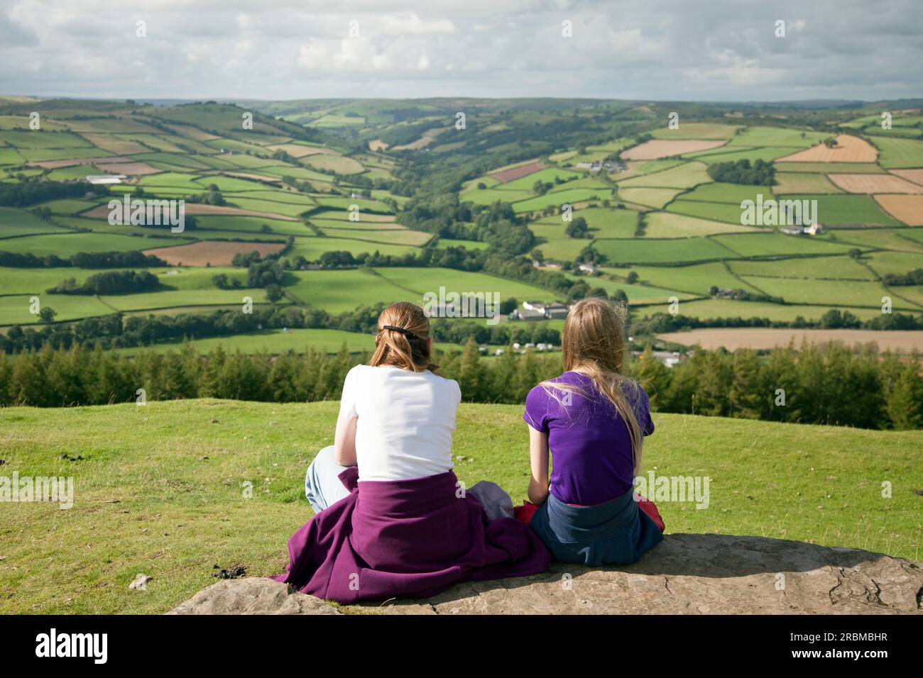 Una donna e una ragazza sedute insieme a guardare la campagna gallese Foto Stock