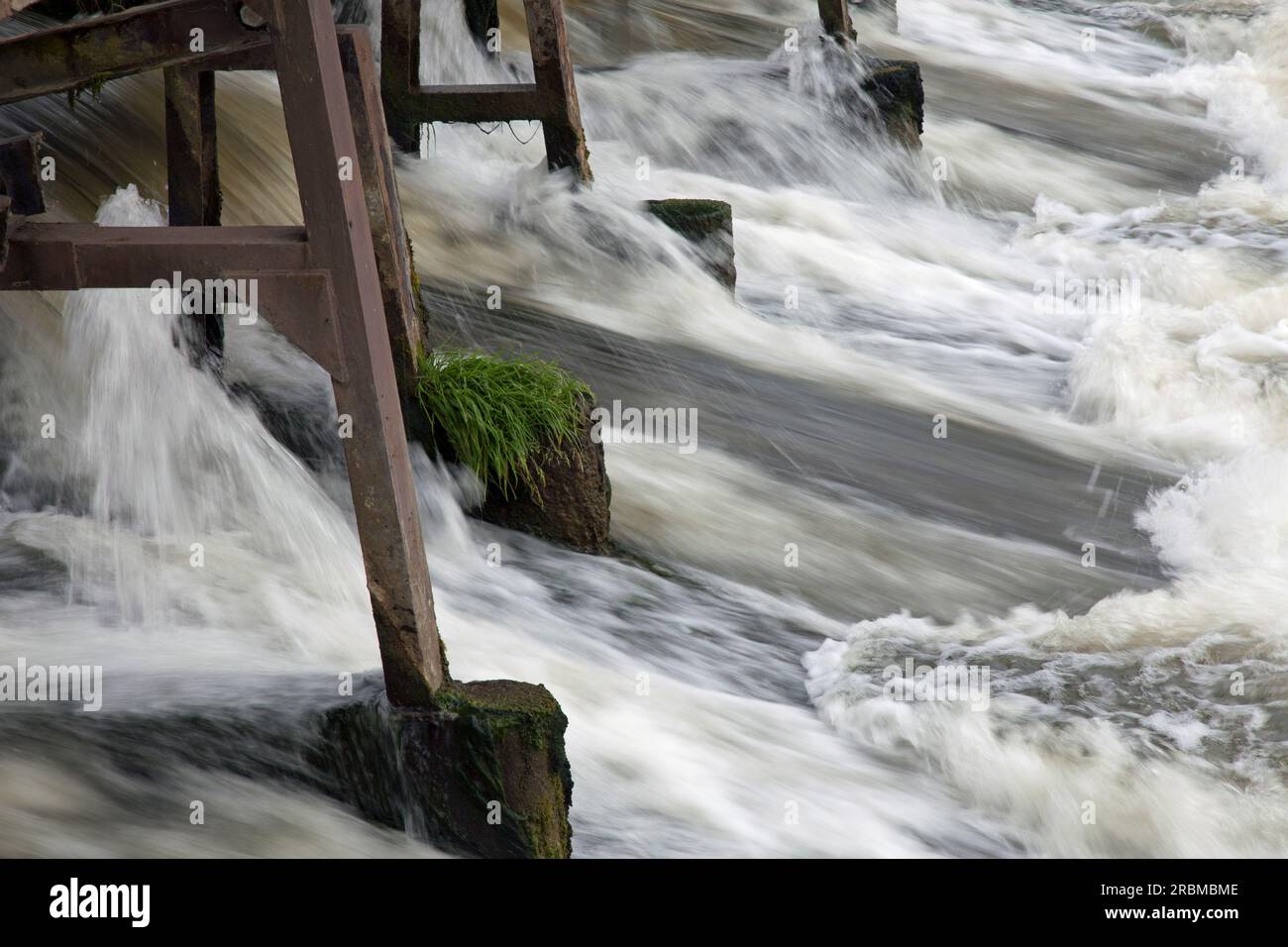 Acqua che scorre attraverso una diga, il Tamigi, Abingdon, Oxfordshire. Velocità più lenta per mostrare il movimento dell'acqua Foto Stock