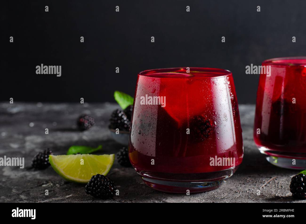 Berry Lemonade, bevanda rinfrescante, cocktail, tè freddo, BlackBerry e Lime Summer drink su sfondo scuro Foto Stock