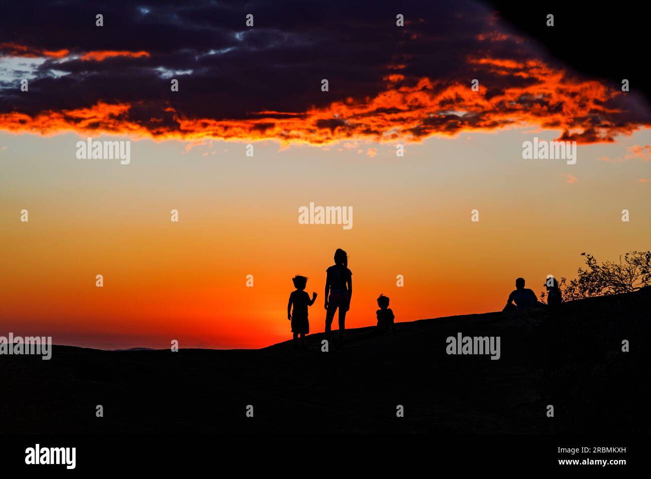 Ombre e sagome di persone che guardano il tramonto sulla montagna dell'isola Spitzkuppe in Namibia, Africa Foto Stock