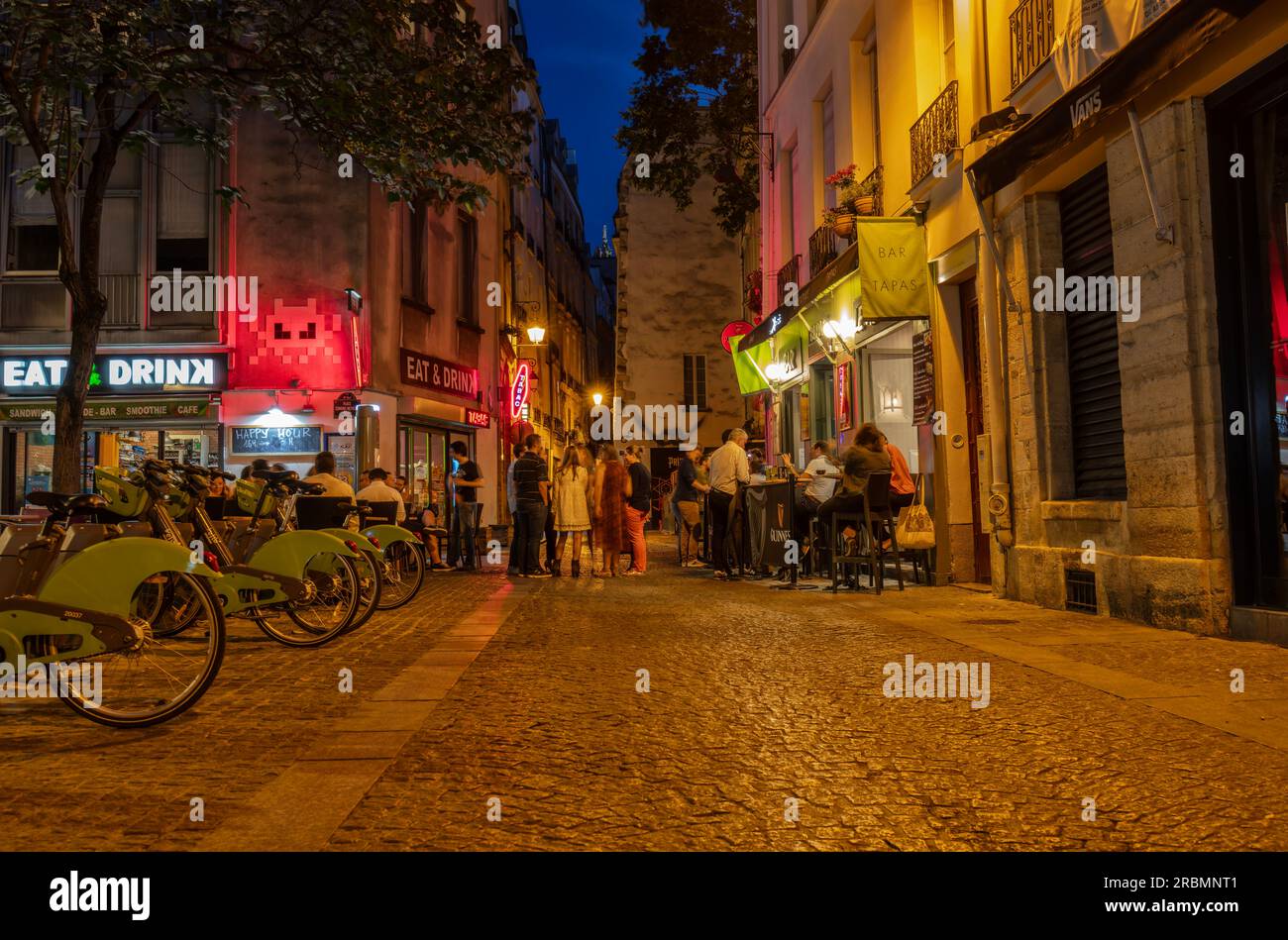 Parigi romantica. La gente passeggia e visita bar e ristoranti al crepuscolo in Rue Quincampoix, 3 Arr. Parigi Foto Stock