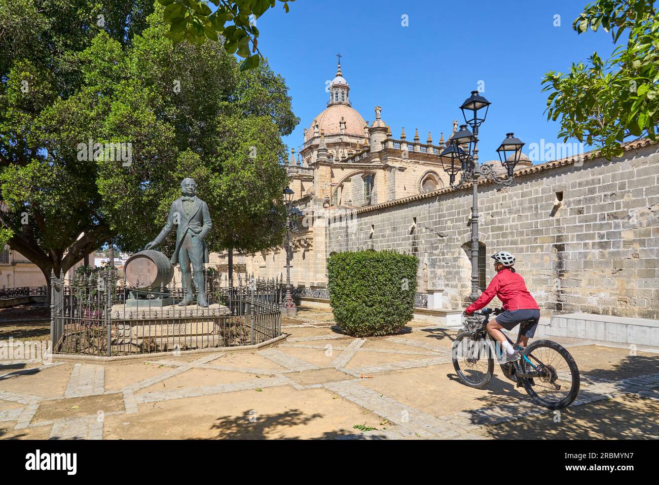 Bella donna anziana attiva che va in bicicletta con la sua mountain bike elettrica nel centro della vecchia città moresca di Jerez de la Frontera, casa della vite Sherry, Andal Foto Stock