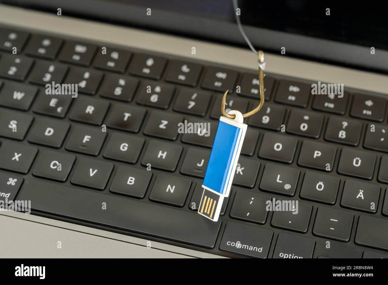 Visualizzazione della criminalità informatica, dello spionaggio e della perdita di dati attraverso una chiavetta USB su un gancio con tastiera del computer in background Foto Stock