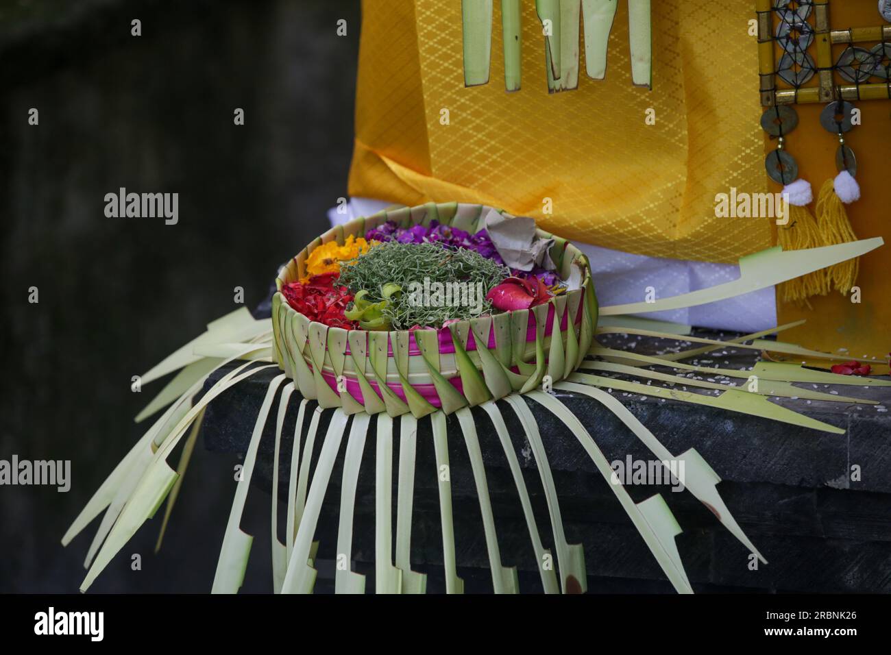 Canang sari, contenitore di bambù intessuto con riso, fiori, incenso, dolci e frutta. Si tratta di un'offerta agli dei, come gesto di gratitudine a Bali Foto Stock