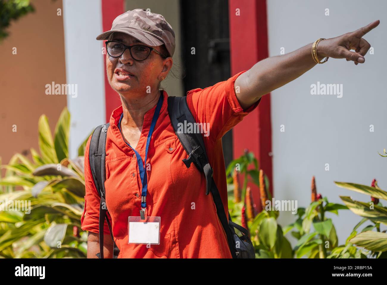 Goa, India -- 10 aprile 2023. Un teleobiettivo di una guida turistica che indica la strada per un gruppo in un tour a piedi di Goa, India. Foto Stock