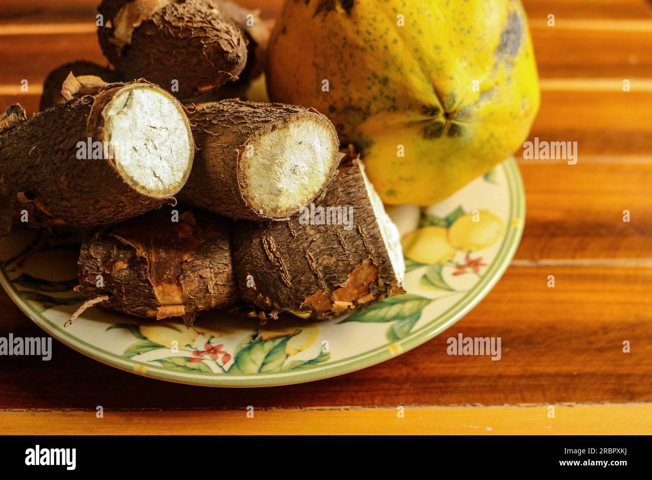 Papaya e manioca in un bellissimo piatto fiorito sul tavolo Foto Stock