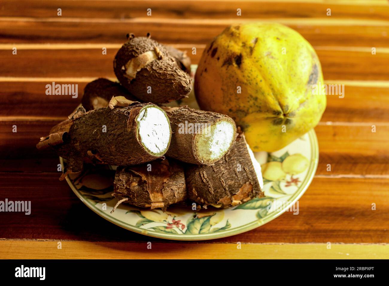 Papaya e manioca in un bellissimo piatto fiorito sul tavolo Foto Stock