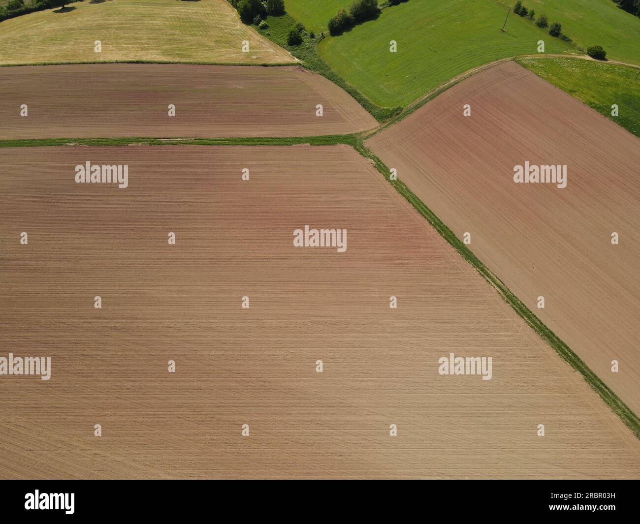 Campi agricoli con terreno arato marrone dall'alto in estate Foto Stock