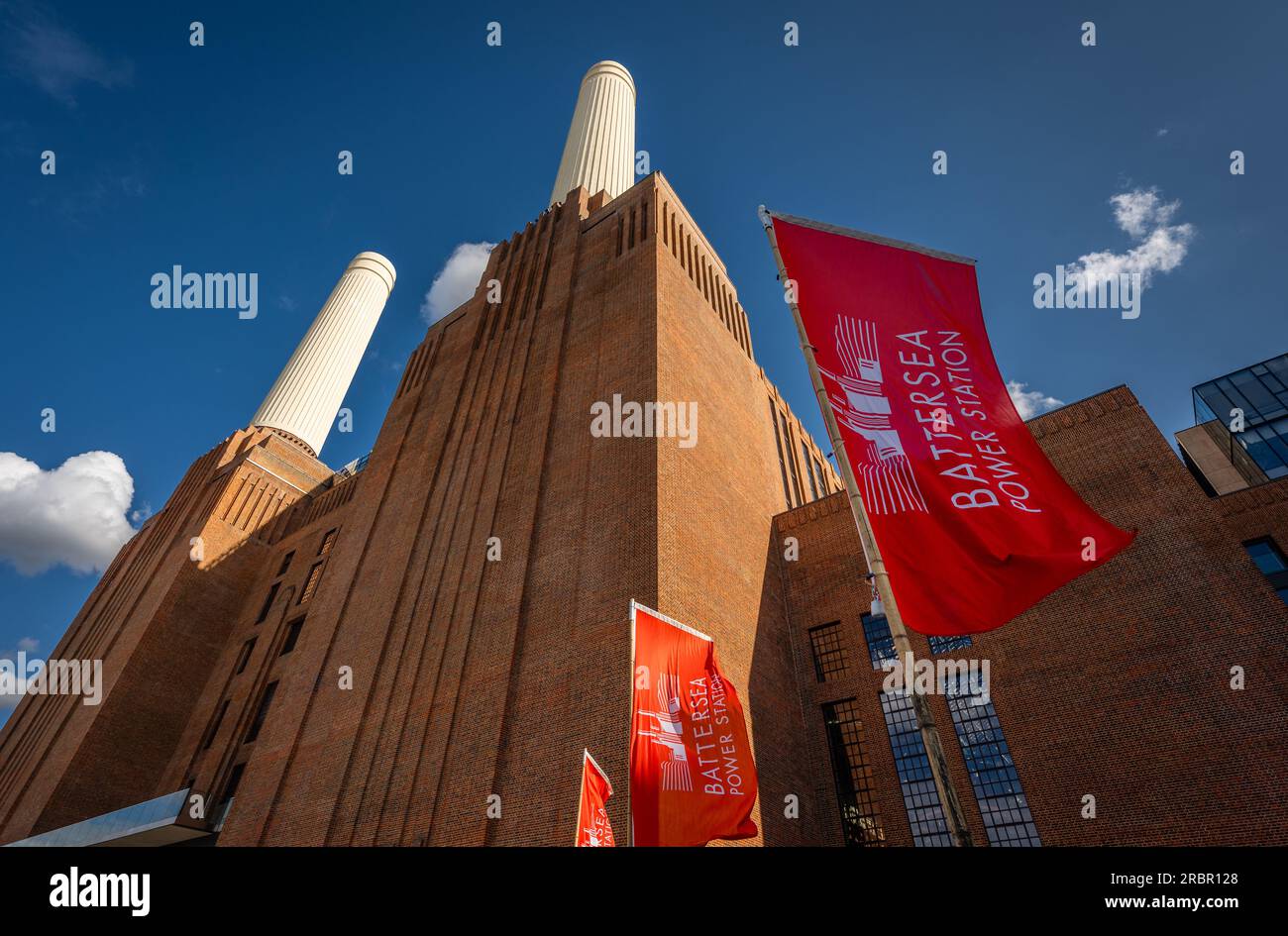 Battersea, Londra, Regno Unito: La centrale elettrica di Battersea è ora riqualificata come destinazione per lo shopping e il tempo libero. Lato nord dell'edificio con bandiere rosse Foto Stock