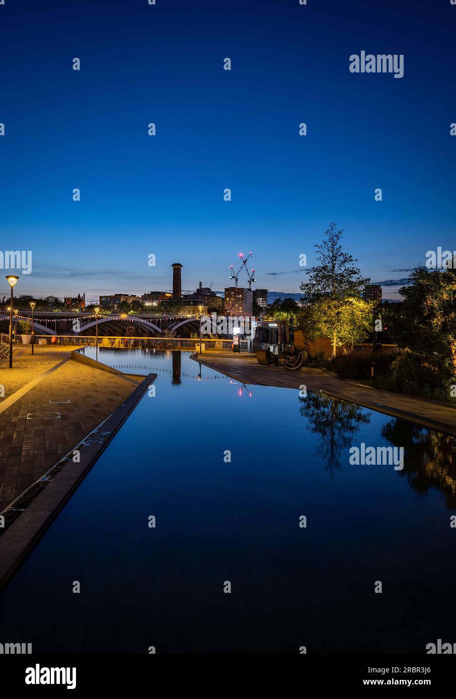 Battersea, Londra, Regno Unito: Stagni in un parco vicino alla centrale elettrica di Battersea. Vista notturna con ritratto rivolto a sud verso Chelsea. Foto Stock