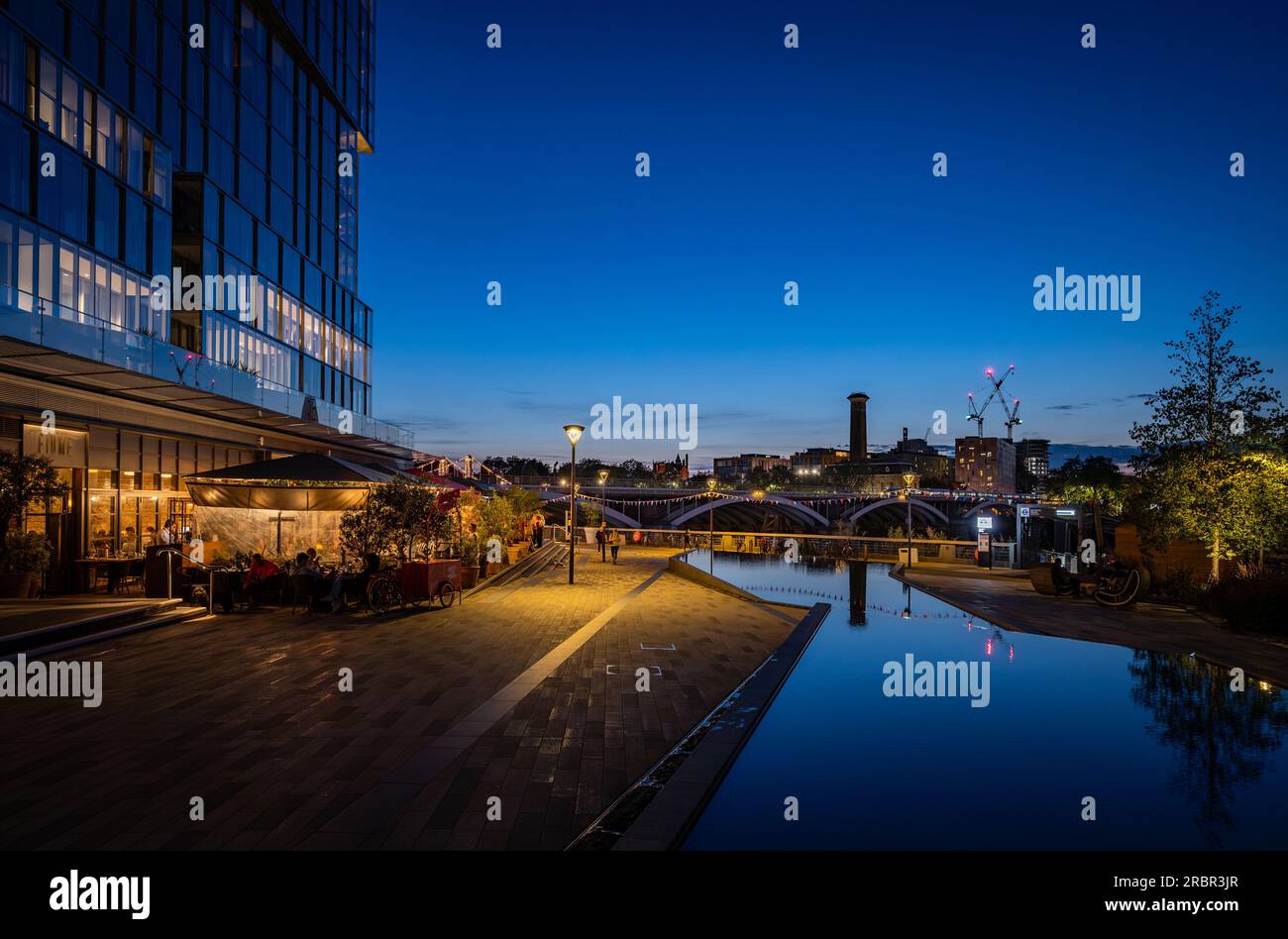 Battersea, Londra, Regno Unito: Stagni in un parco e ristorante vicino alla centrale elettrica di Battersea. Vista notturna del paesaggio guardando a sud verso Chelsea. Foto Stock