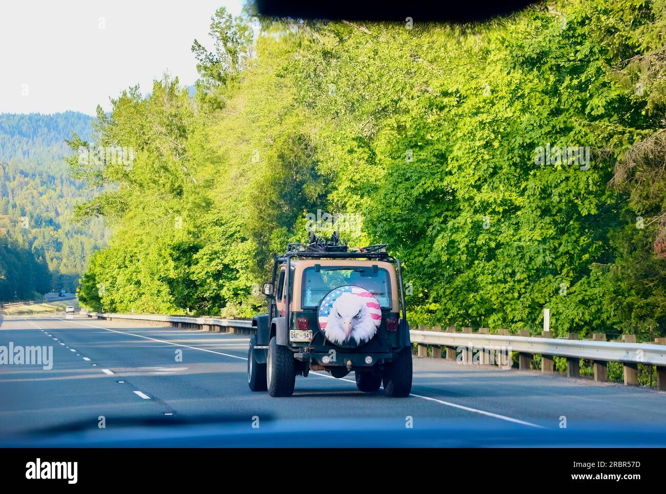 Jeep Wrangler SUV con stelle e strisce patriottiche e copertura della ruota di scorta con aquila dalla testa calva che viaggia verso nord sull'Interstate 5 Oregon USA Foto Stock