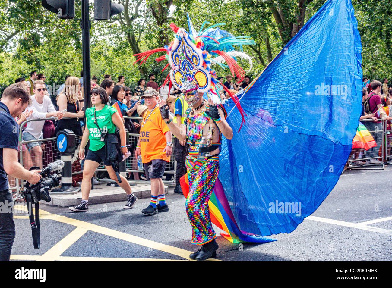 Un partecipante all'evento annuale London Pride il 1 luglio 2023 su Piccadilly a Londra indossando un costume colorato e sfavillante con ali blu Foto Stock
