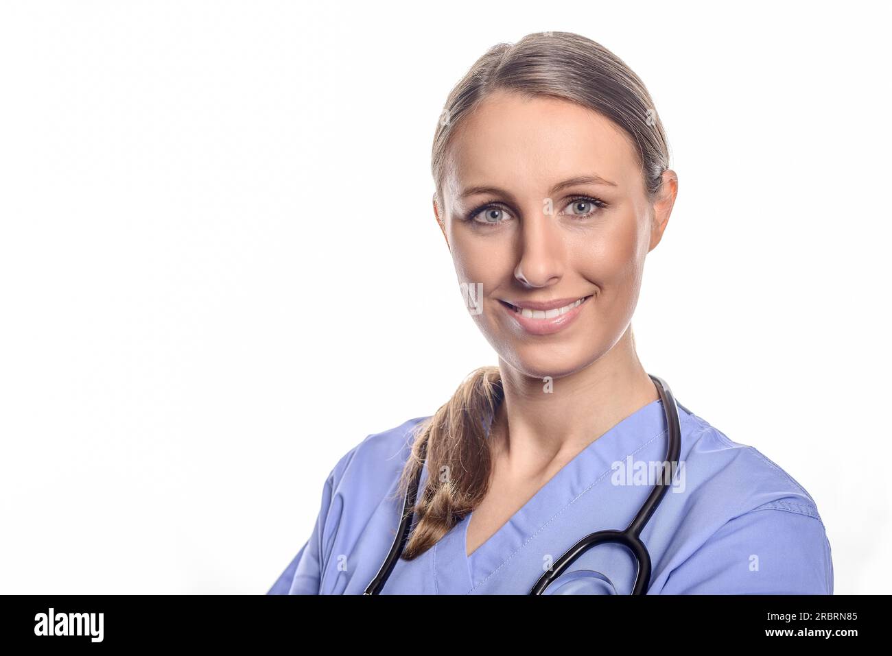 Ritratto di un amichevole giovani donne medico medico usura uniforme e uno stetoscopio attorno al collo mentre posa con bracci ripiegati Foto Stock