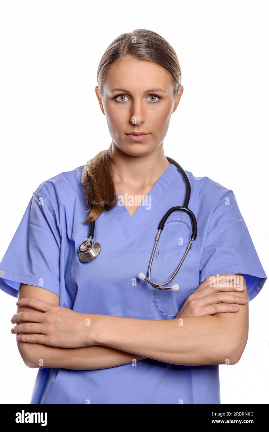 Ritratto di un amichevole giovani donne medico medico usura uniforme e uno stetoscopio attorno al collo mentre posa con bracci ripiegati Foto Stock