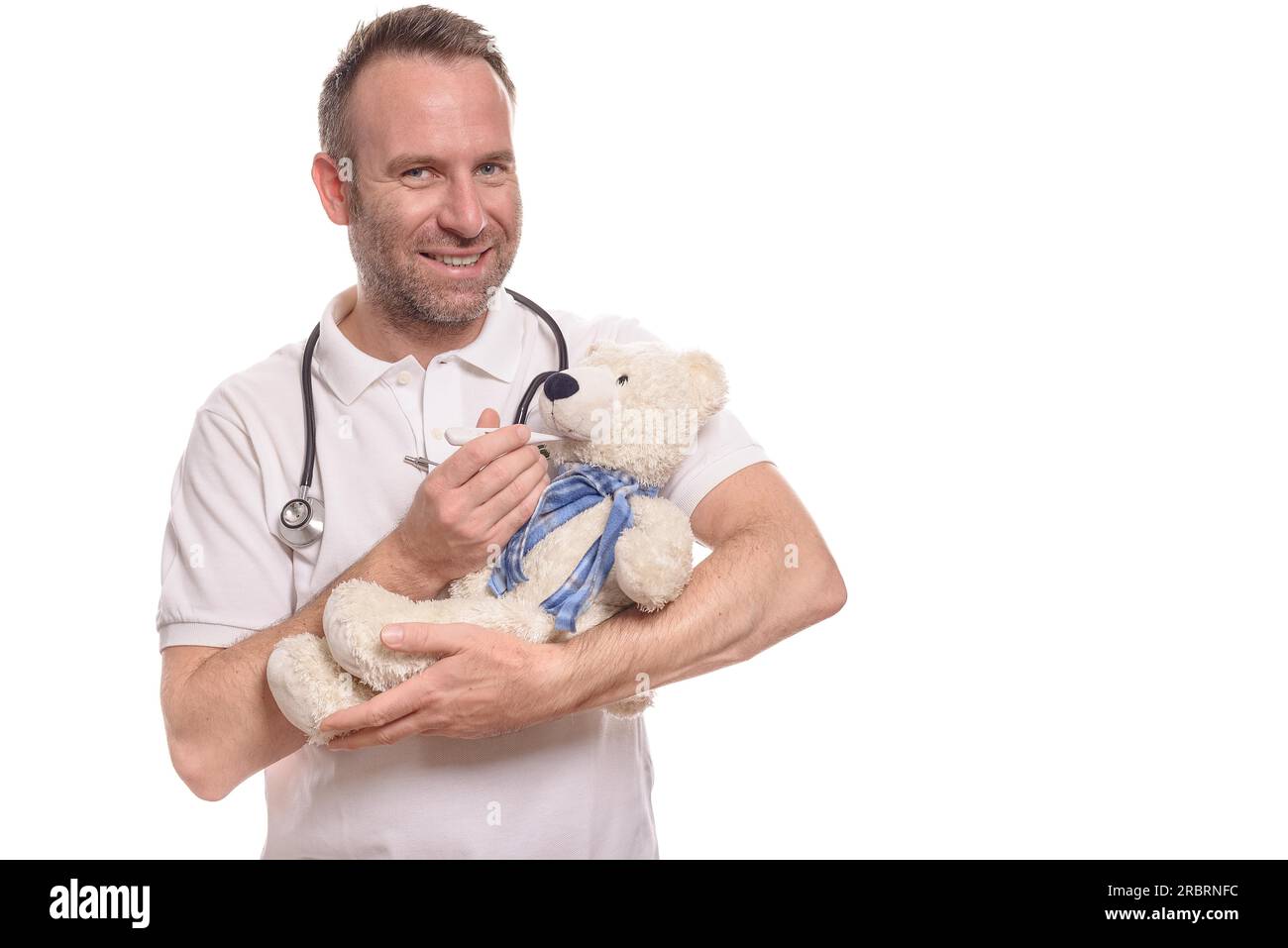 Infermiere o pediatra sorridente e scrupoloso con un orsacchiotto cullato tra le braccia che prende la temperatura con un termometro per rassicurare un Foto Stock