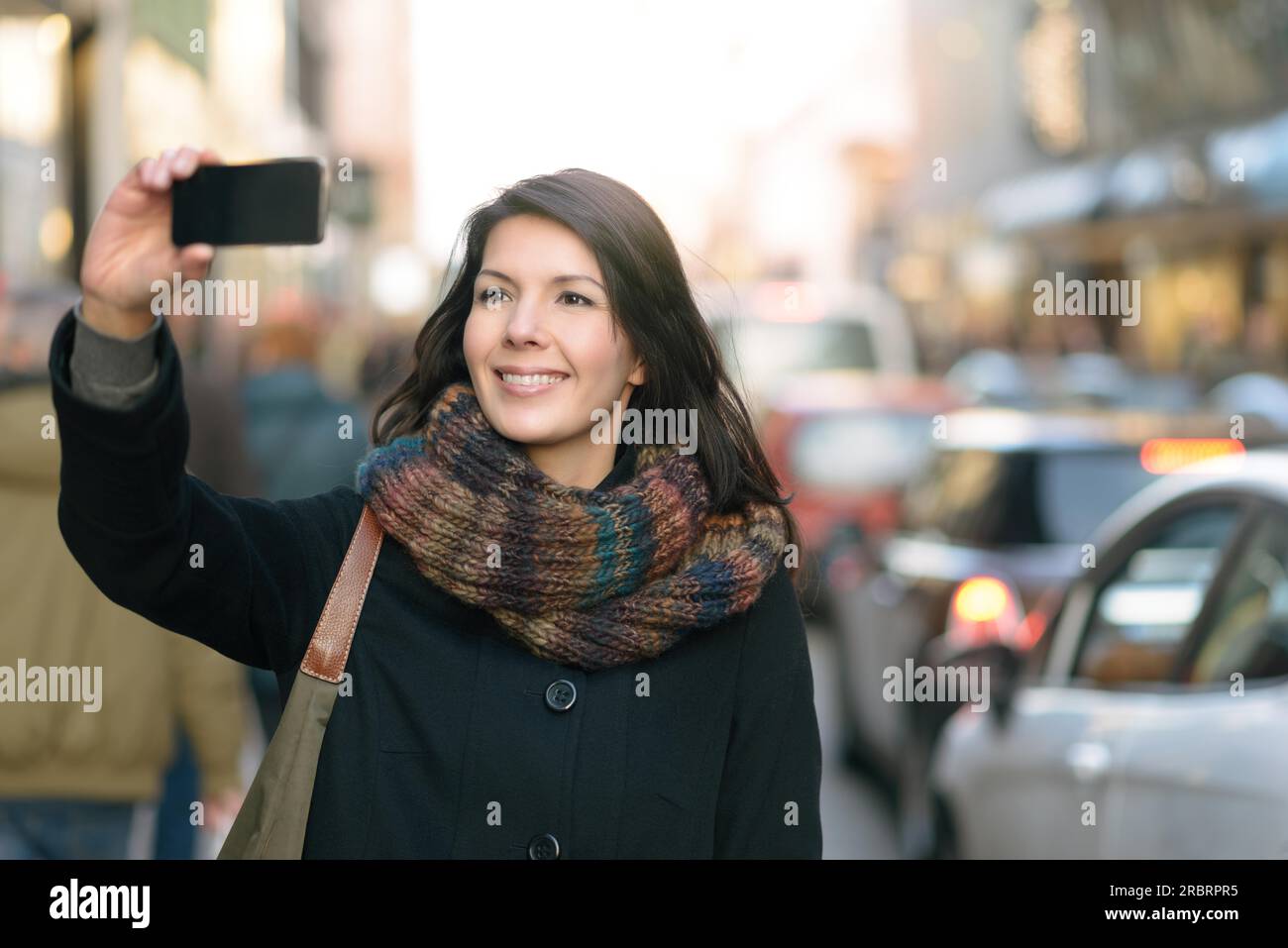 Chiudere fino alla moda donna felice in autunno moda tenendo Selfie mentre al via della città Foto Stock