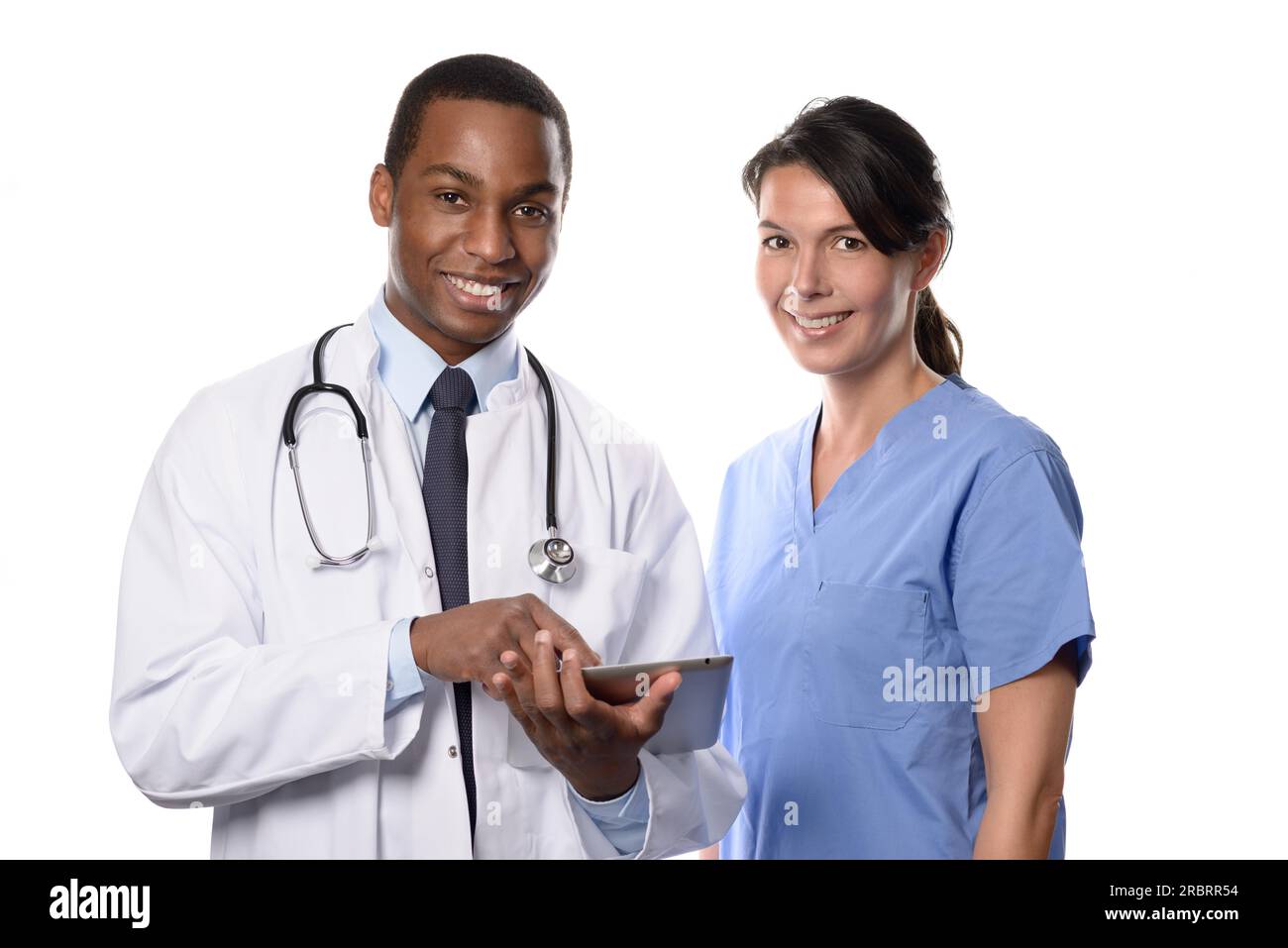 Due colleghi medici consultano un tablet-pc cercando cartelle e cartelle dei pazienti con un bel giovane medico africano in un camice bianco da laboratorio e. Foto Stock
