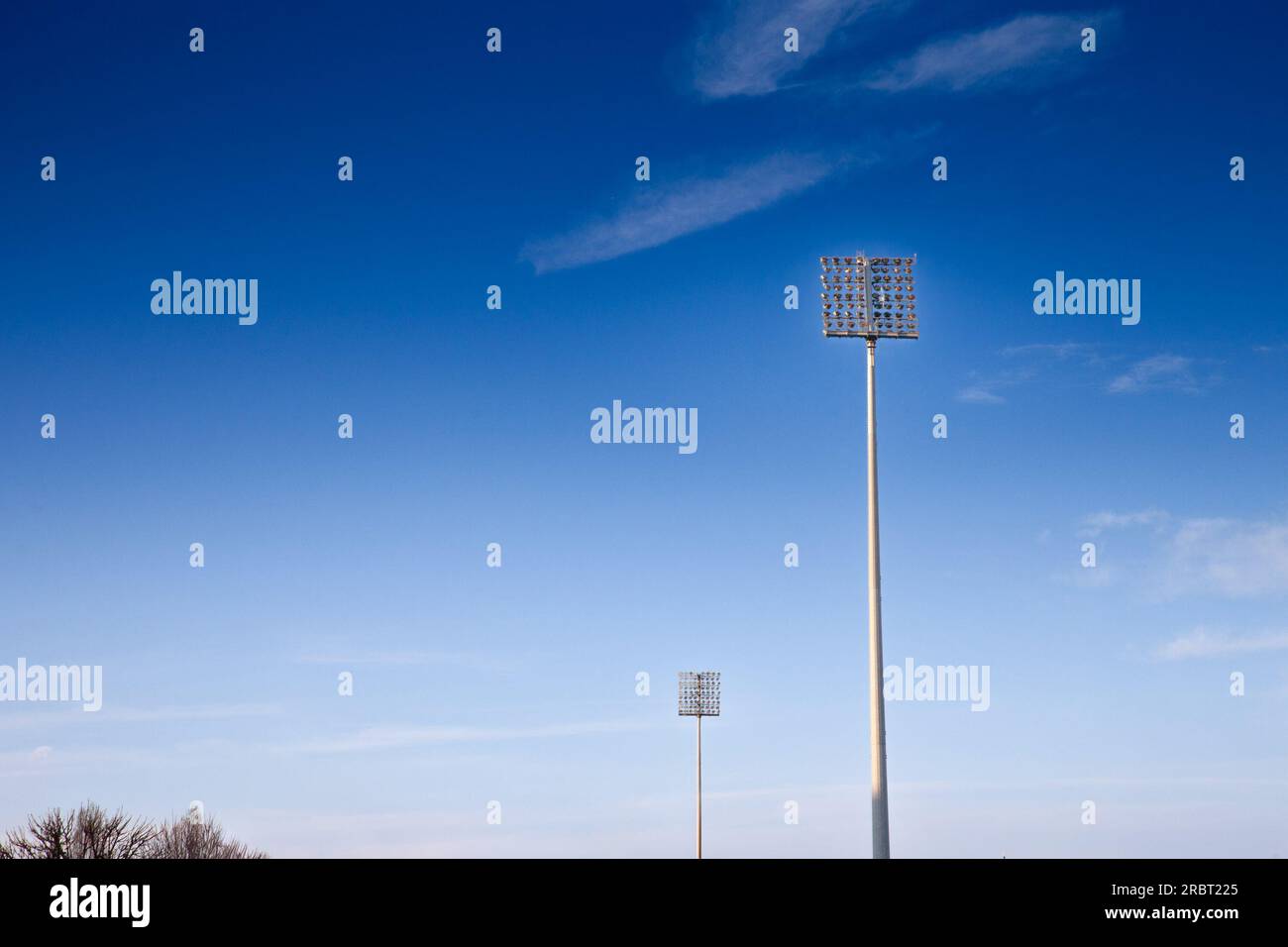 Foto dei fari dello stadio nel pomeriggio, con un cielo blu, utilizzati per illuminare gli eventi sportivi in uno stadio. Foto Stock