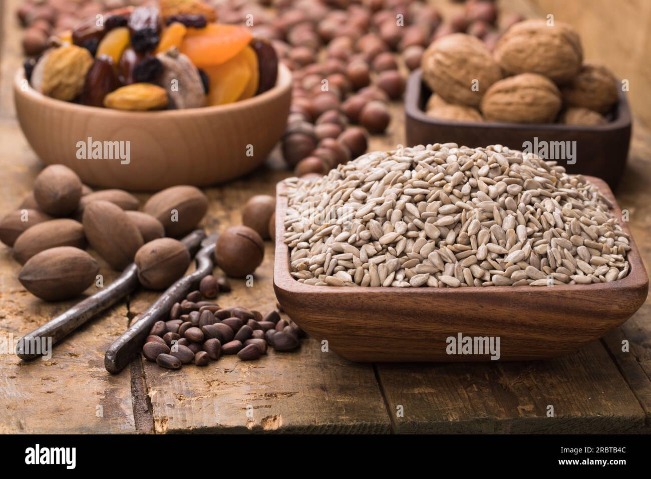semi di girasole sbucciati in un recipiente su un tavolo di legno. Alimenti utili per vegetariani e vegani. Foto Stock