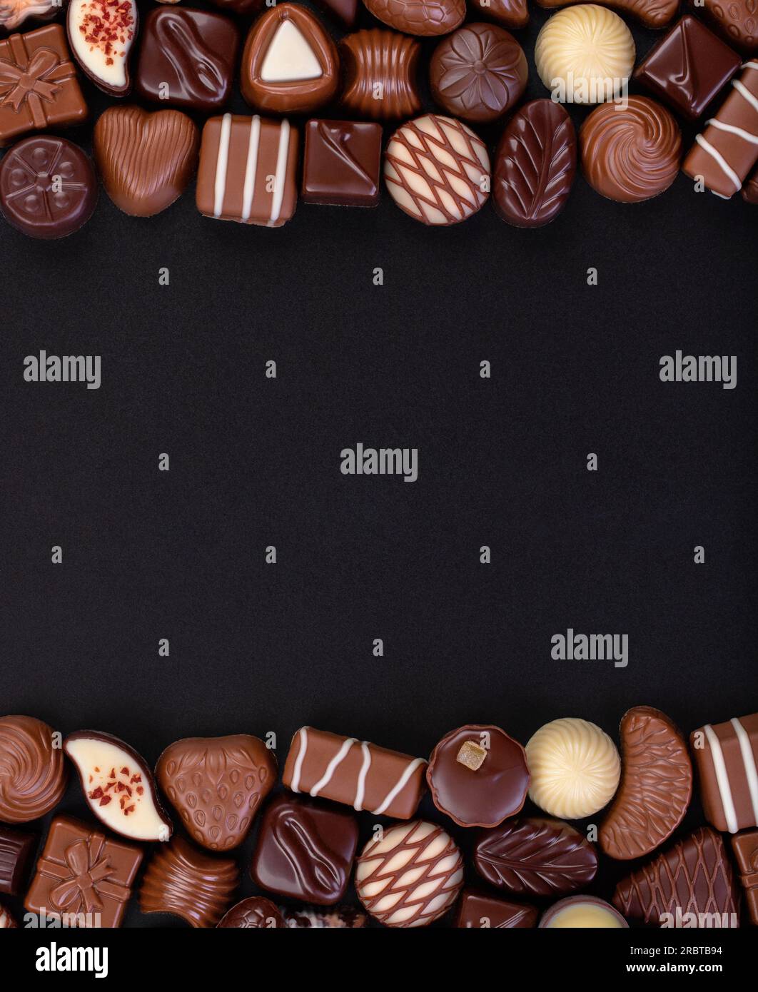 caramelle al cioccolato sul tavolo nero con spazio per la copia, sfondo di dolci. Foto Stock