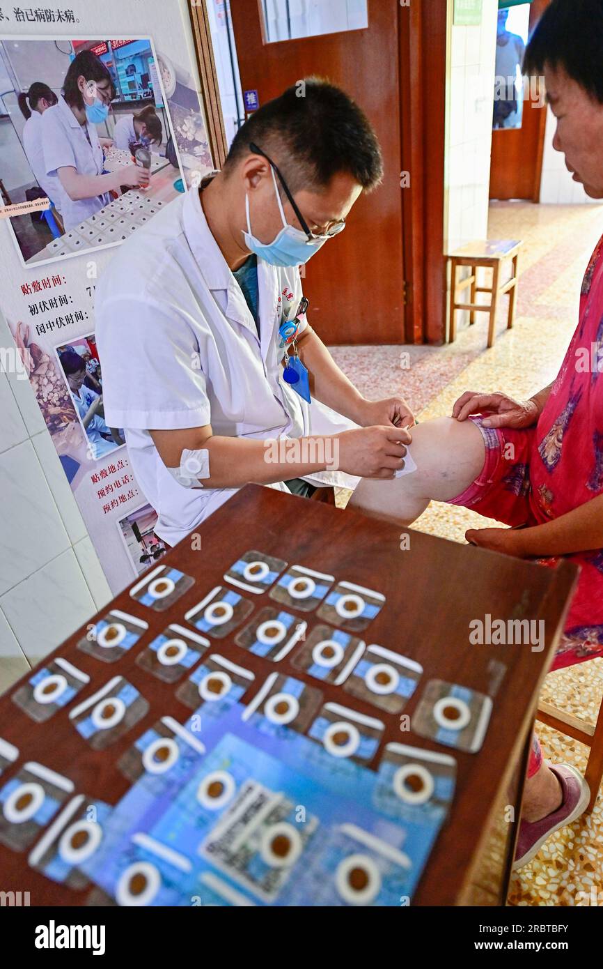 QINGZHOU, CINA - 11 LUGLIO 2023 - presso il Dipartimento di riabilitazione di Medicina tradizionale Cinese dell'ospedale del popolo, si applica un operatore medico Foto Stock