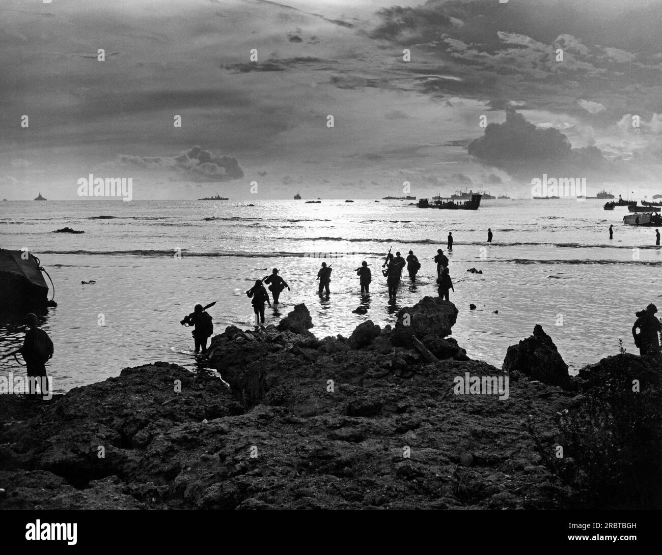 Tinian, Isole Marianne Settentrionali, 24 luglio 1944 i soldati attraversano acque poco profonde dopo aver sbarcato una nave da sbarco con equipaggio della Guardia Costiera durante l'invasione dell'isola di Tinian. Foto Stock