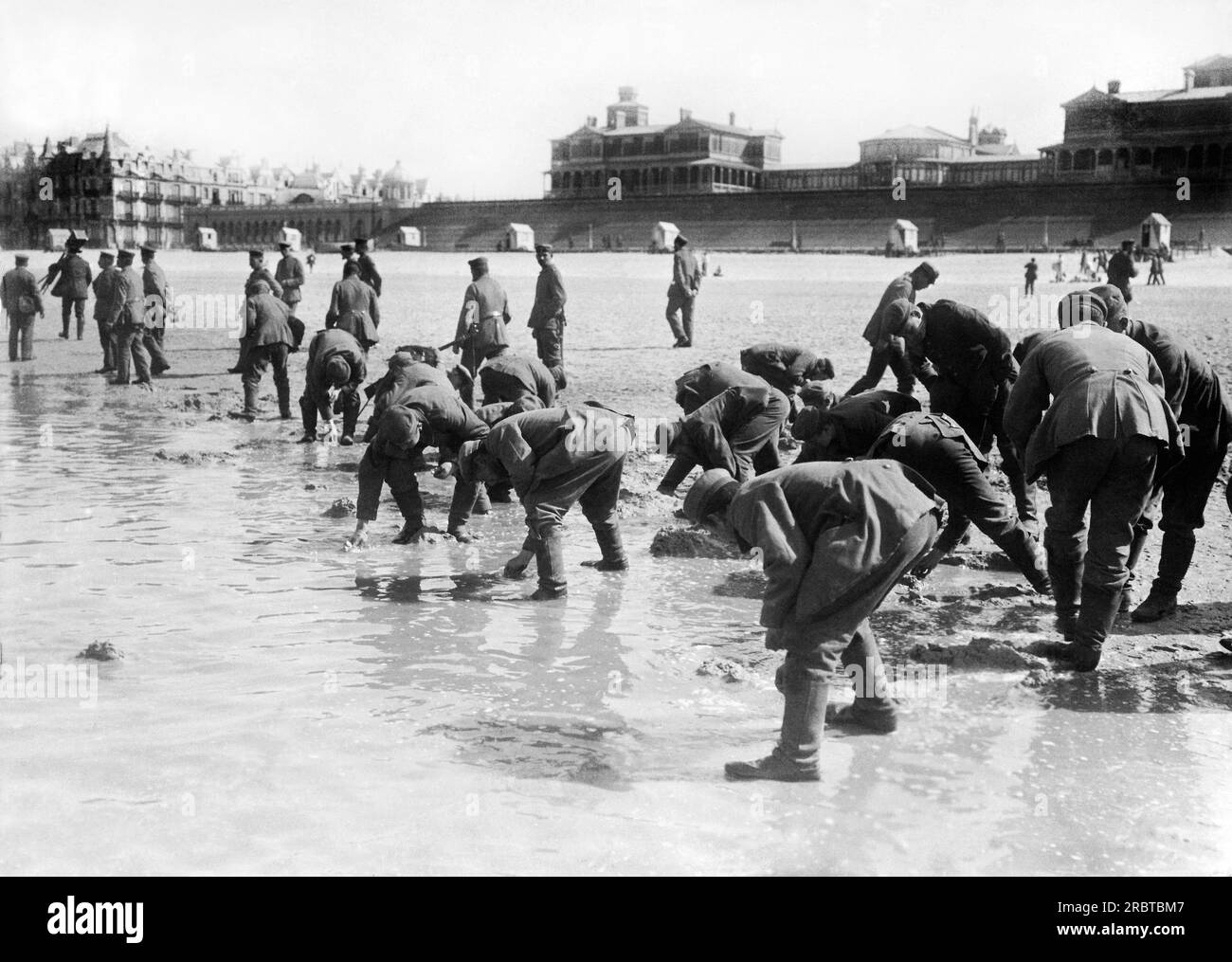 Europa: circa 1916 soldati tedeschi alla ricerca di conchiglie sulla spiaggia. Foto Stock