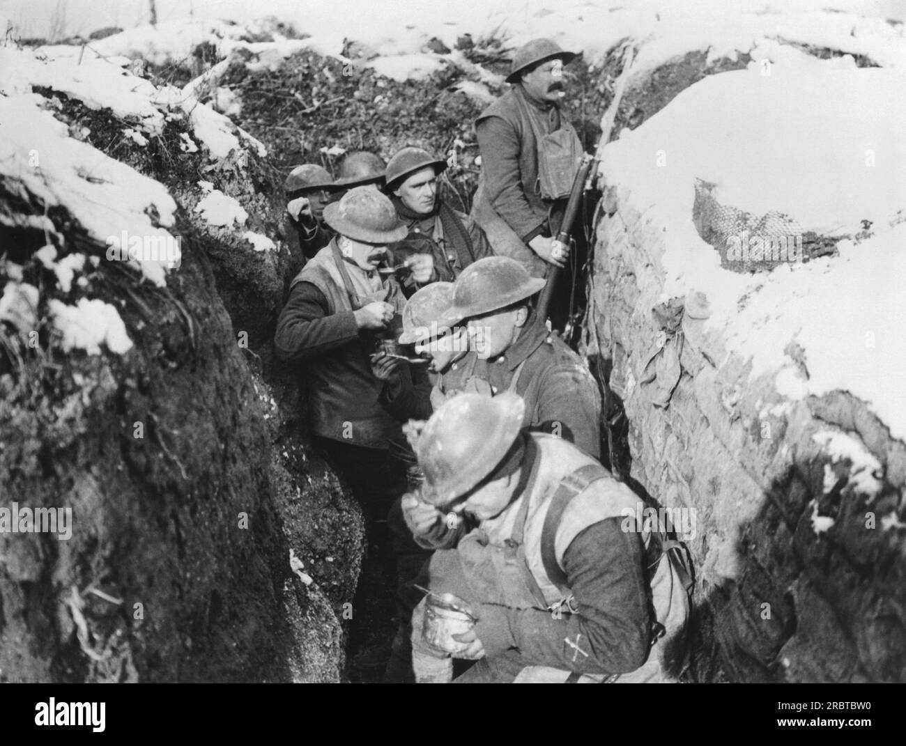 Francia: circa 1917 Chow tempo per le truppe britanniche nelle trincee mentre un soldato sta a guardare. Foto Stock