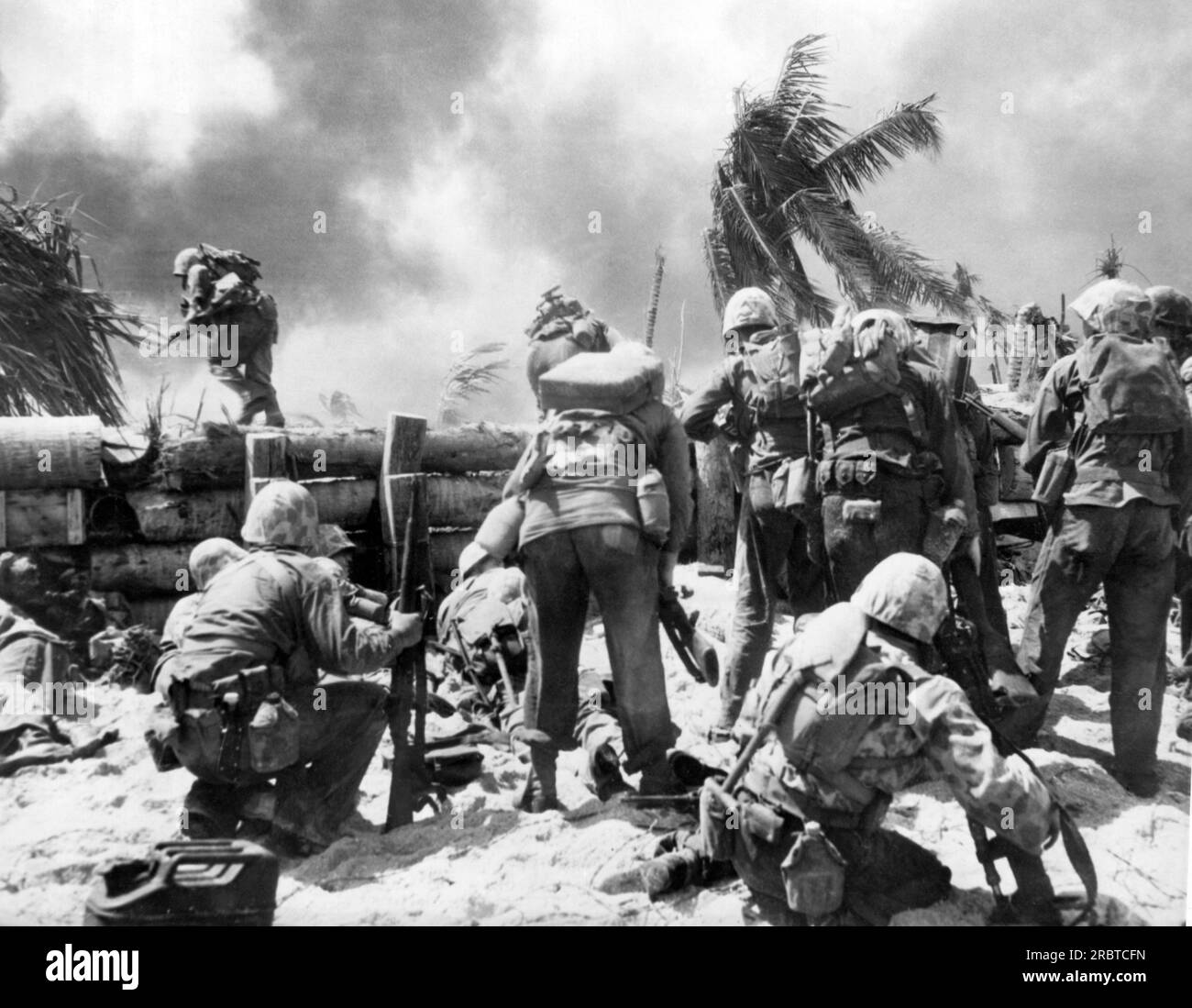 Isole Gilbert, Oceano Pacifico: Novembre 1943 due marine statunitensi attraversano le fortificazioni delle mura giapponesi durante la battaglia per l'isola giapponese di Tarawa. Foto Stock
