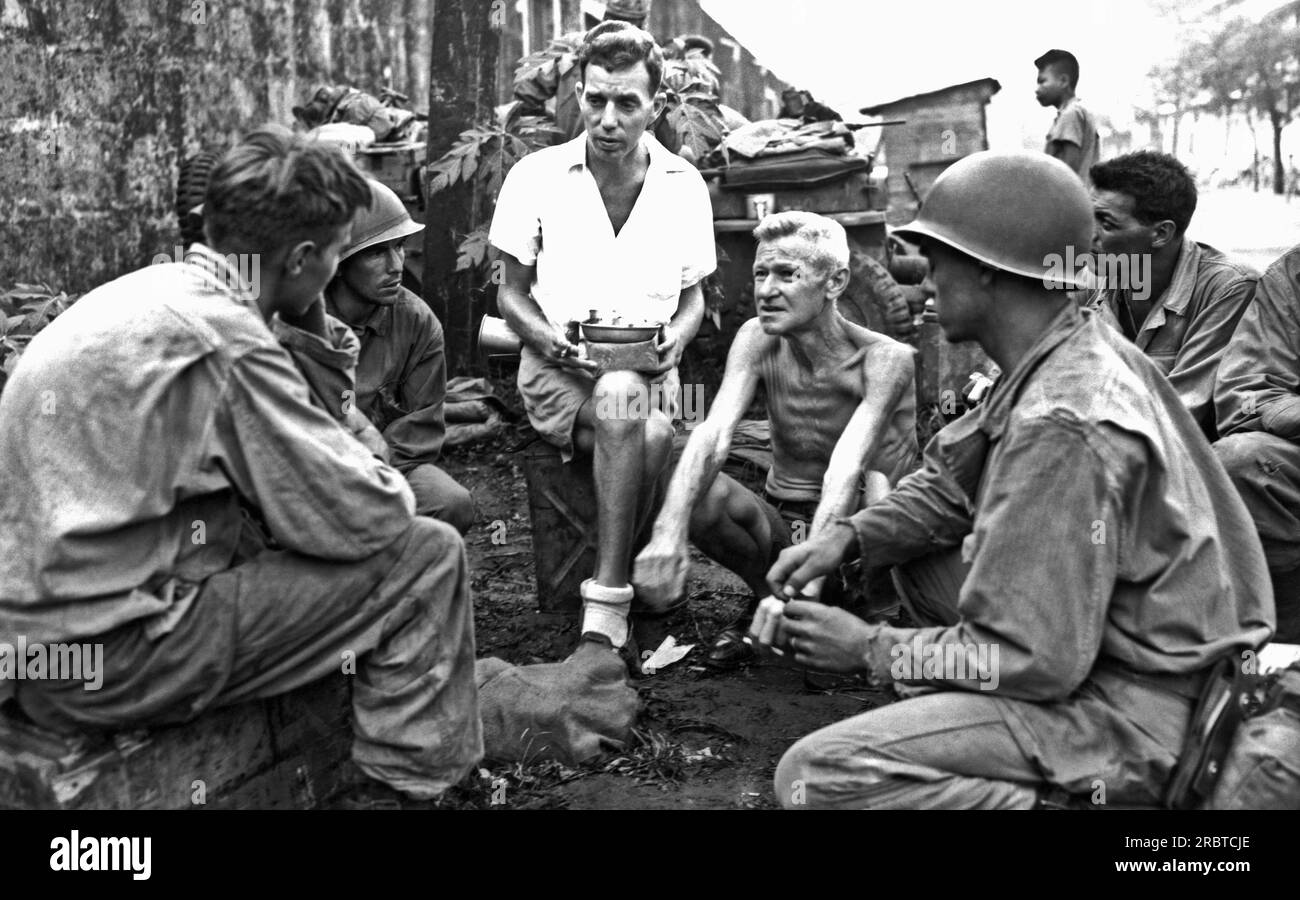 Manila, Filippine: 11 febbraio 1945 i soldati americani che facevano parte della liberazione del campo di prigionia giapponese di Bilibid si fermano per parlare con due internati che erano stati nel campo di prigionia per due anni. Foto Stock