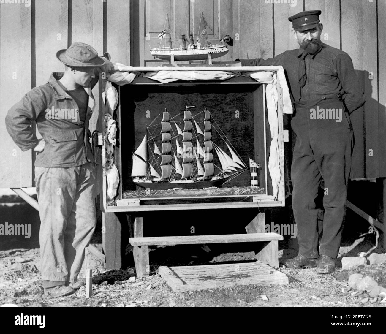 Fort McPherson, Georgia: c. 1918 questi due marinai tedeschi, ora prigionieri di guerra, trascorrono il loro tempo a costruire bellissimi modelli di navi. La nave a vela vola secondo lo standard "W.P.Frye". Foto Stock