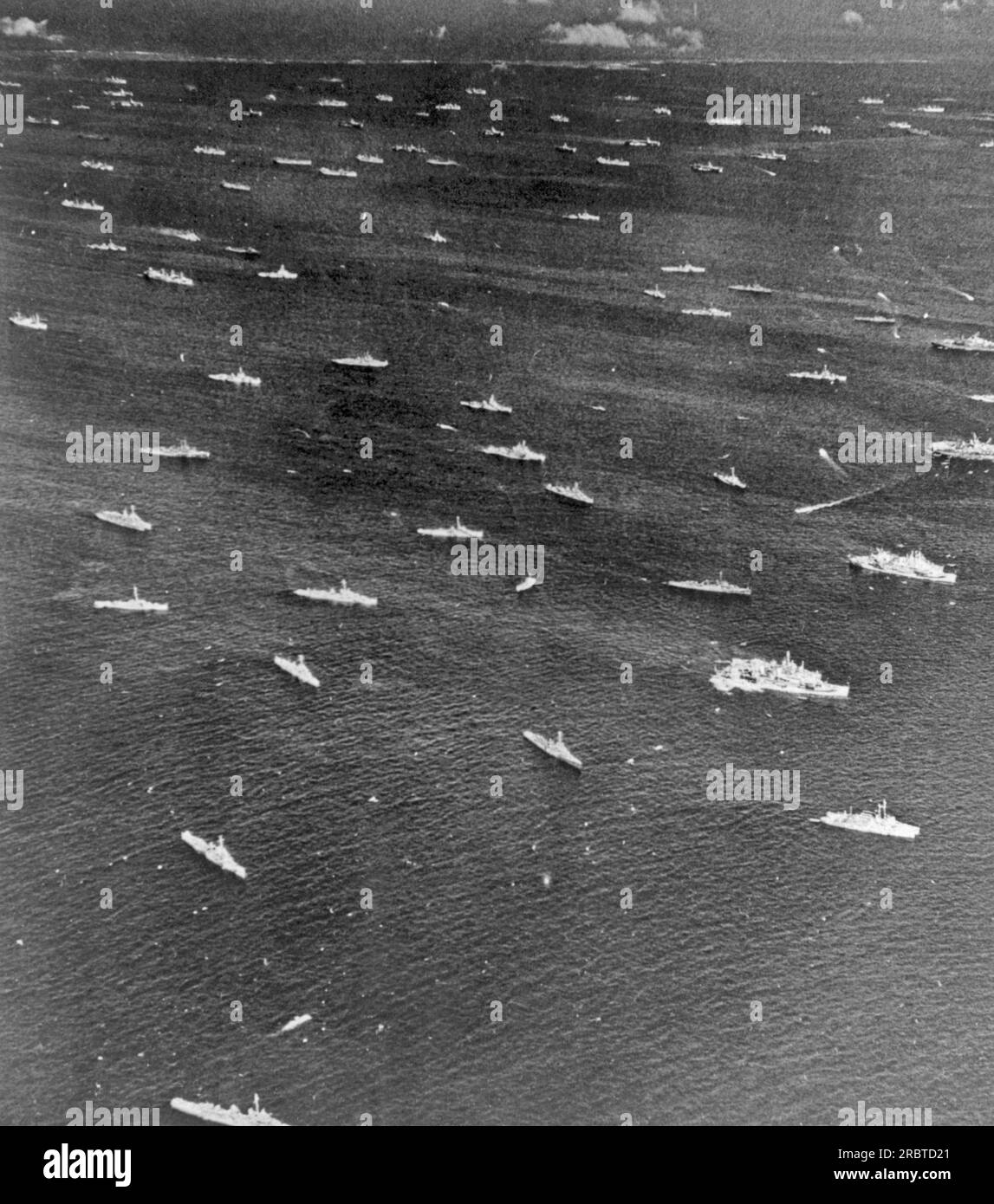 Oceano Pacifico: Aprile 1945 Una Task Force della Marina degli Stati Uniti con quasi ogni tipo di nave da combattimento mostrata all'ancora. In primo piano ci sono cacciatorpediniere e scorta di cacciatorpediniere, a destra ci sono i trasporti. Nel terzo superiore ci sono navi cisterna, navi della classe Essex, navi leggere della classe Independence, più navi cisterna e navi da carico. Foto Stock