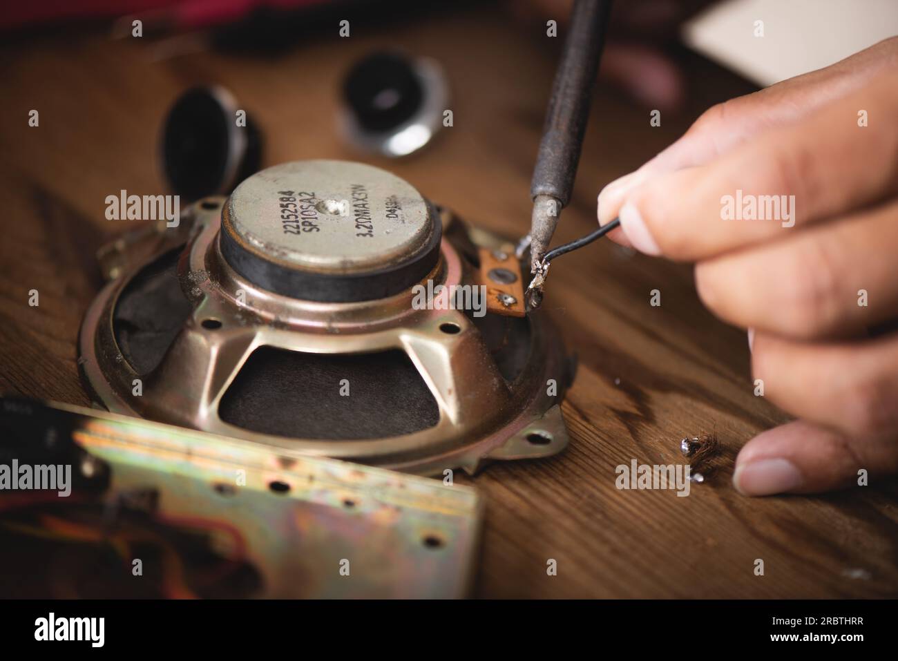 Tecnico che utilizza il saldatore per riparare il dispositivo elettronico. Foto Stock