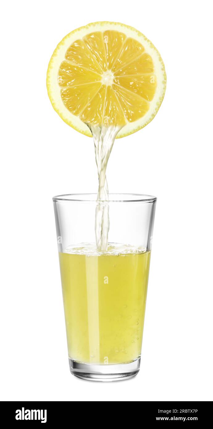 Versare il succo appena spremuto dal limone nel bicchiere su sfondo bianco Foto Stock