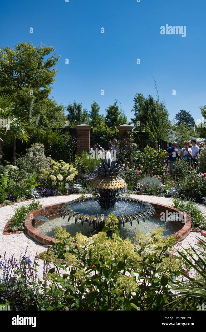 I visitatori ammirano uno dei giardini dello spettacolo al RHS Hampton Court Flower Show di Londra Foto Stock